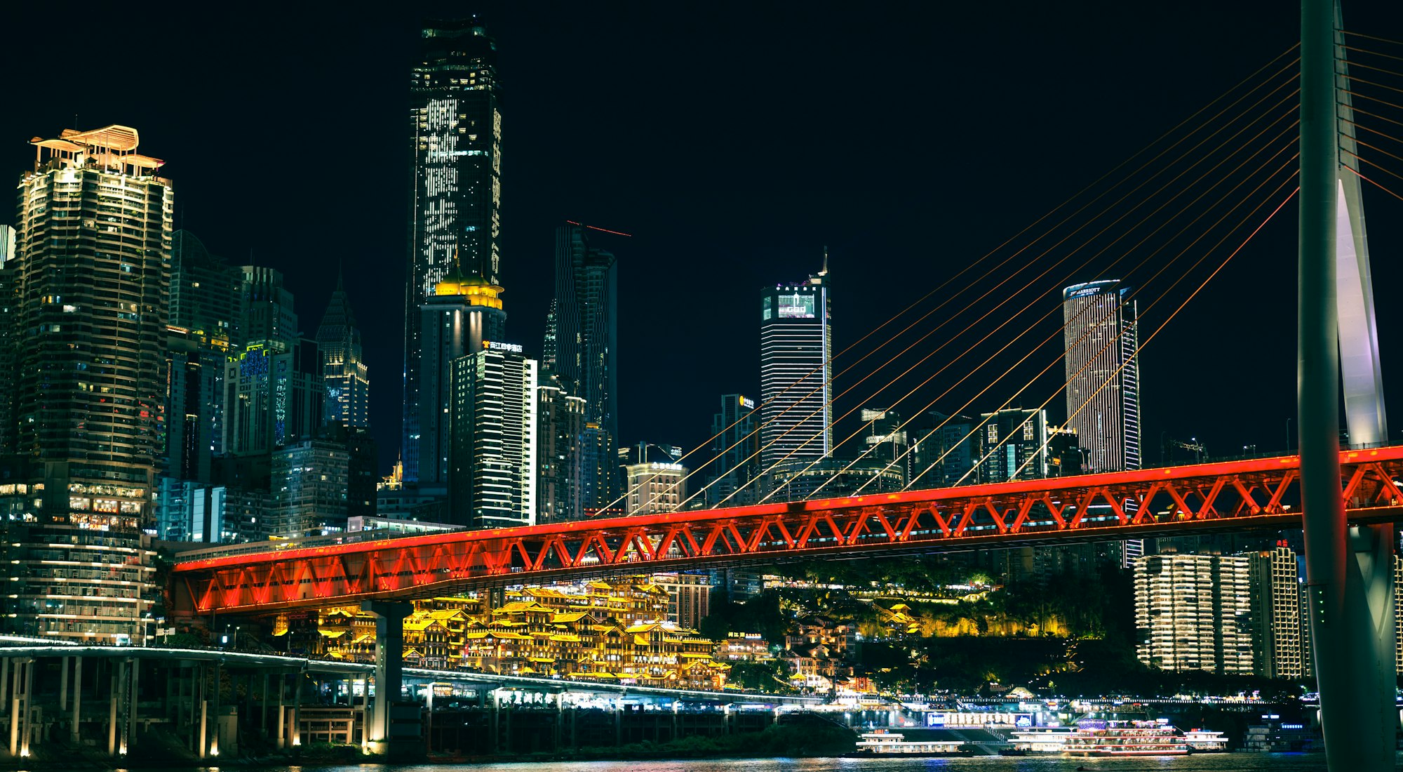 夜晚江边的红色大桥和高楼